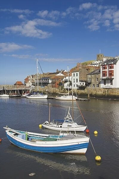 Whitby church and fishing boats in the harbour, Whitby, North Yorkshire