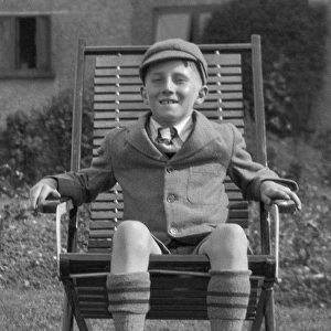 Schoolboy sitting in a garden chair