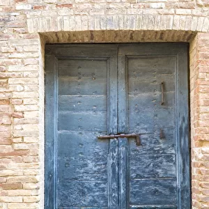 Italy, Tuscany. Old blue door with iron latch in a village in Tuscany
