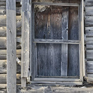 Window detail from a weathered log cabin in winter, Nulato, Alaska, USA